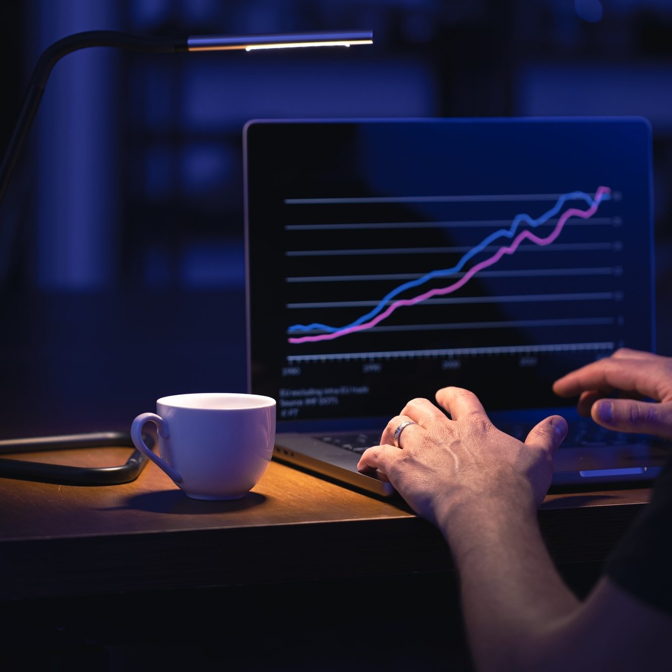 Broker looking at laptop analyzing stock market invest trading stocks graph.
