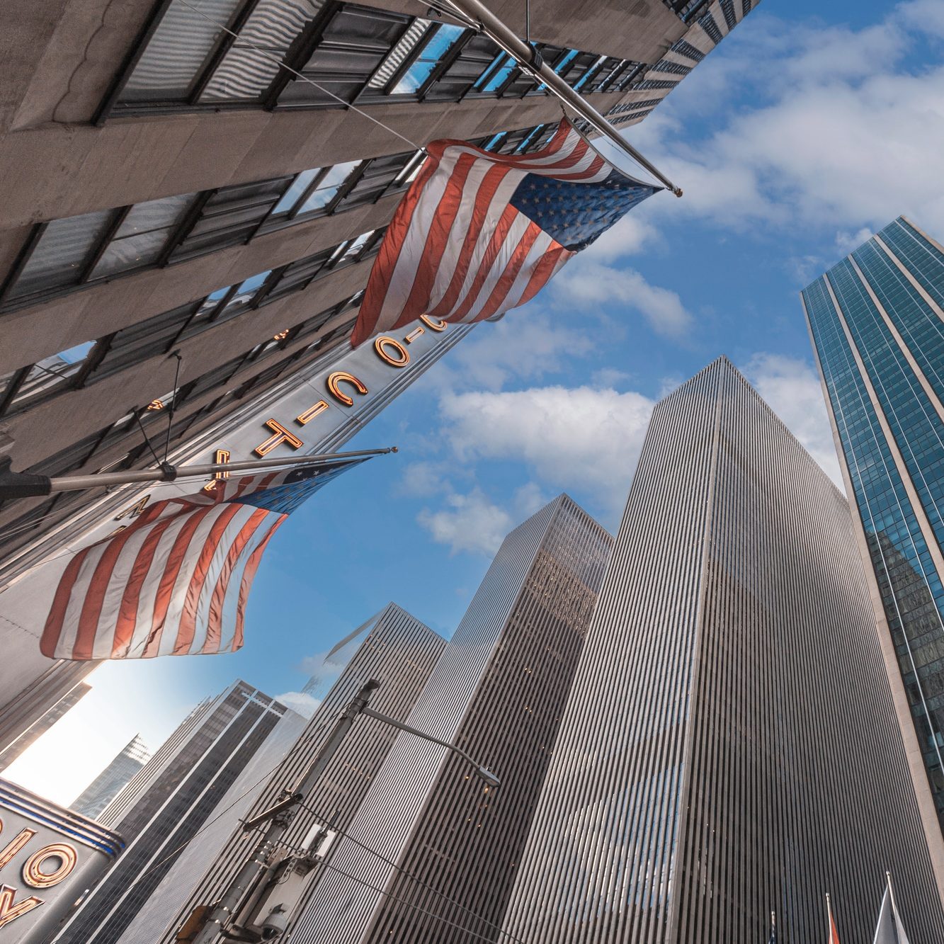 Skyscrapers in Manhattan with American flags and sky above in New York